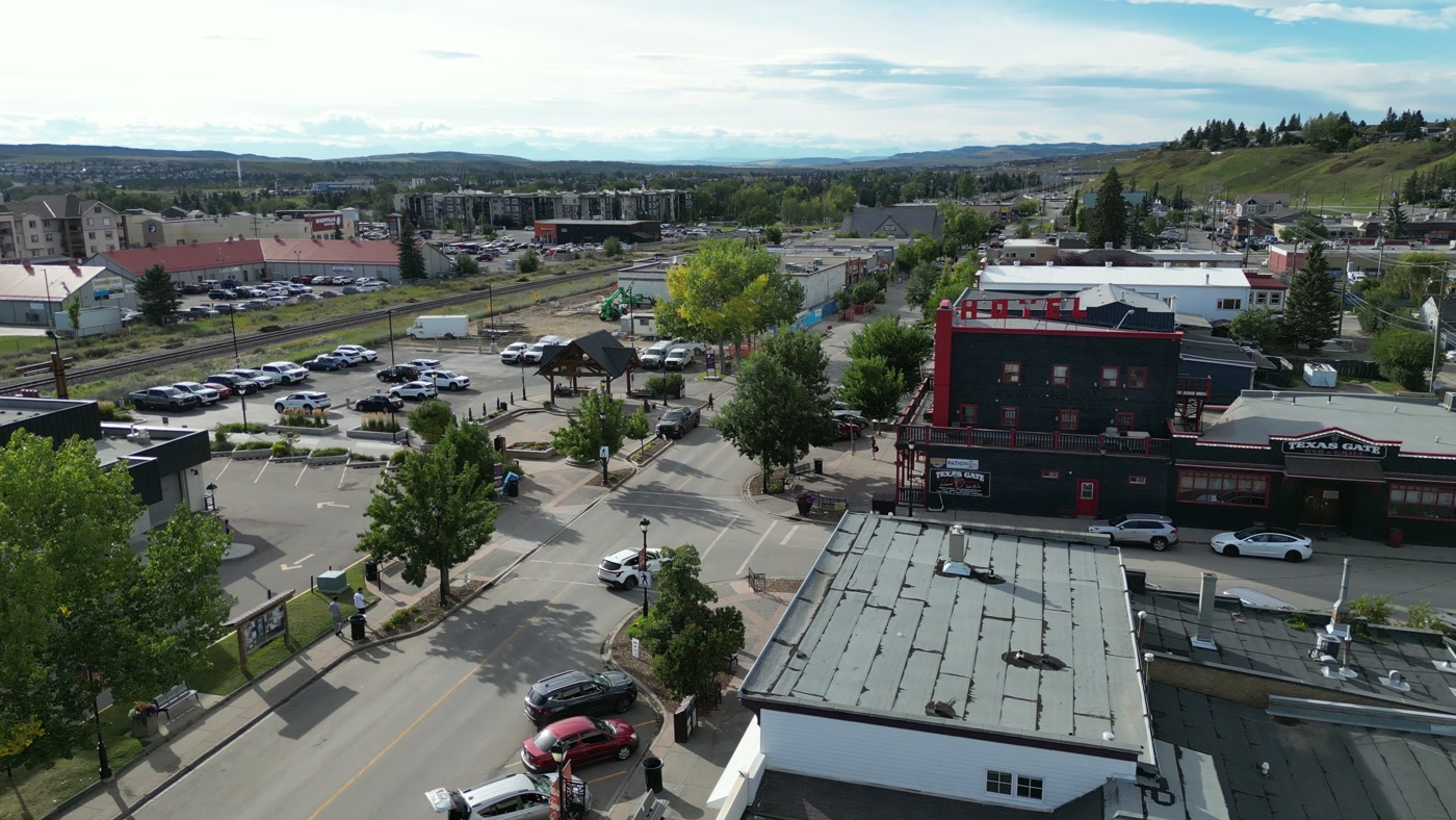 Downtown Cochrane from above the shop: the rail line, the lots behind it and the hills beyond
