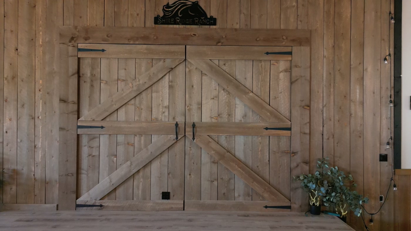 Weathered timber barn doors with iron strap hinges in a plank wall — a material reference