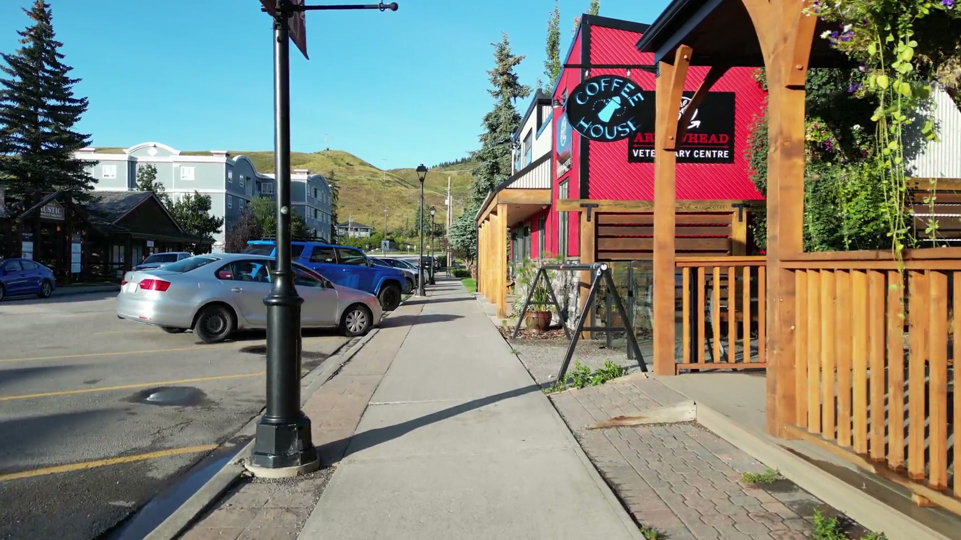 At eye level down the 2nd Avenue West sidewalk, past a lamp post, the porch of Cochrane Coffee Traders and its Coffee House sign, then the red clinic, before lifting over the parked cars