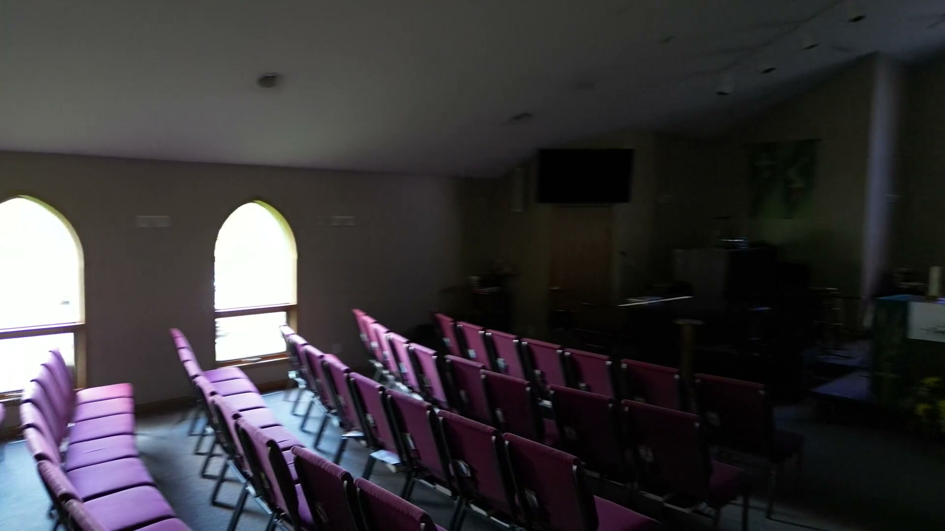 Across the empty chairs of the sanctuary at St. Peter's at half speed, the clear arched windows down the wall throwing morning light along the rows