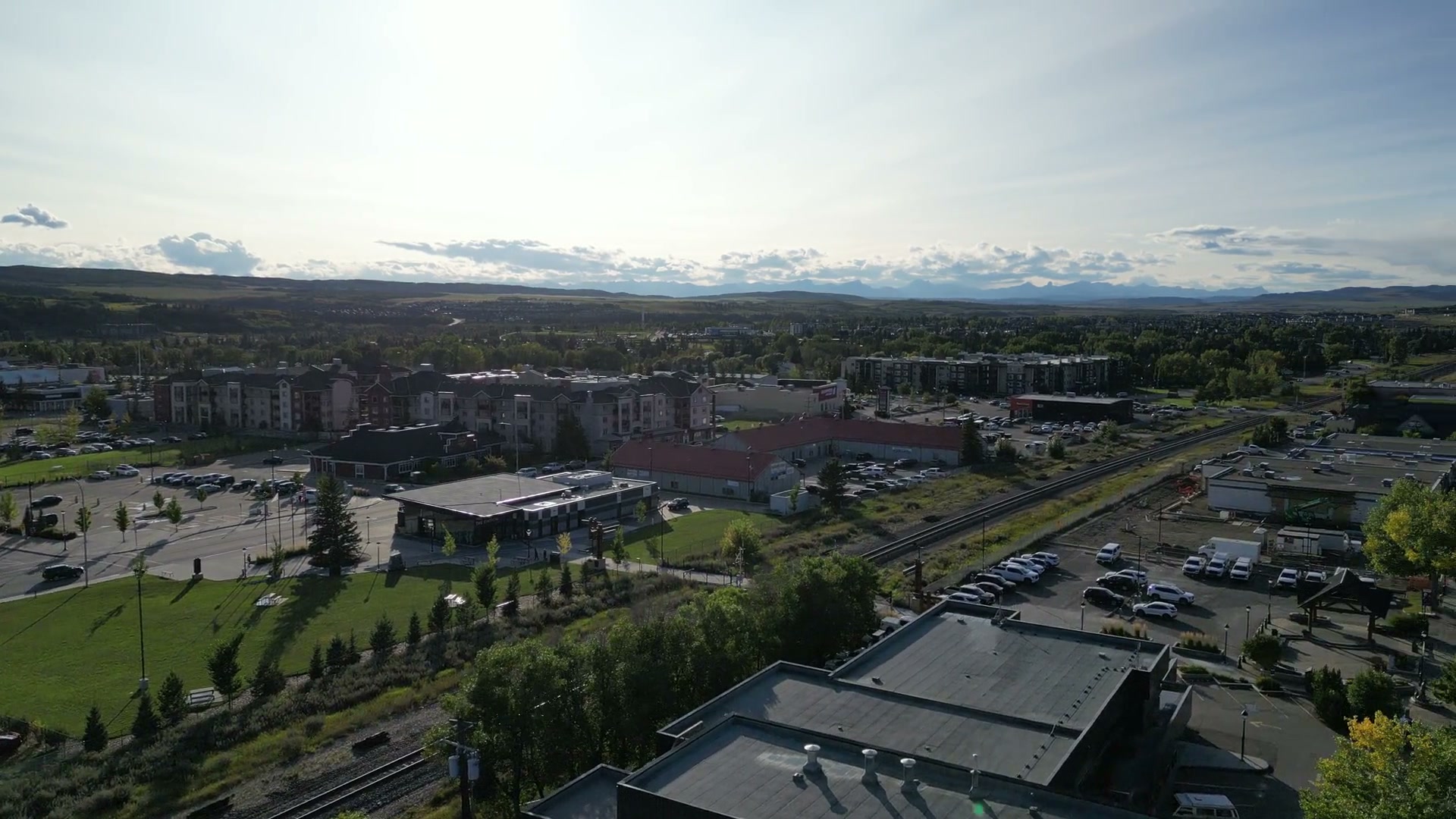 Rising from the Sunny Side Up sign over the flat roof until Cochrane opens out: the tracks curving away, apartment blocks, green lawns and a long line of hills on the horizon