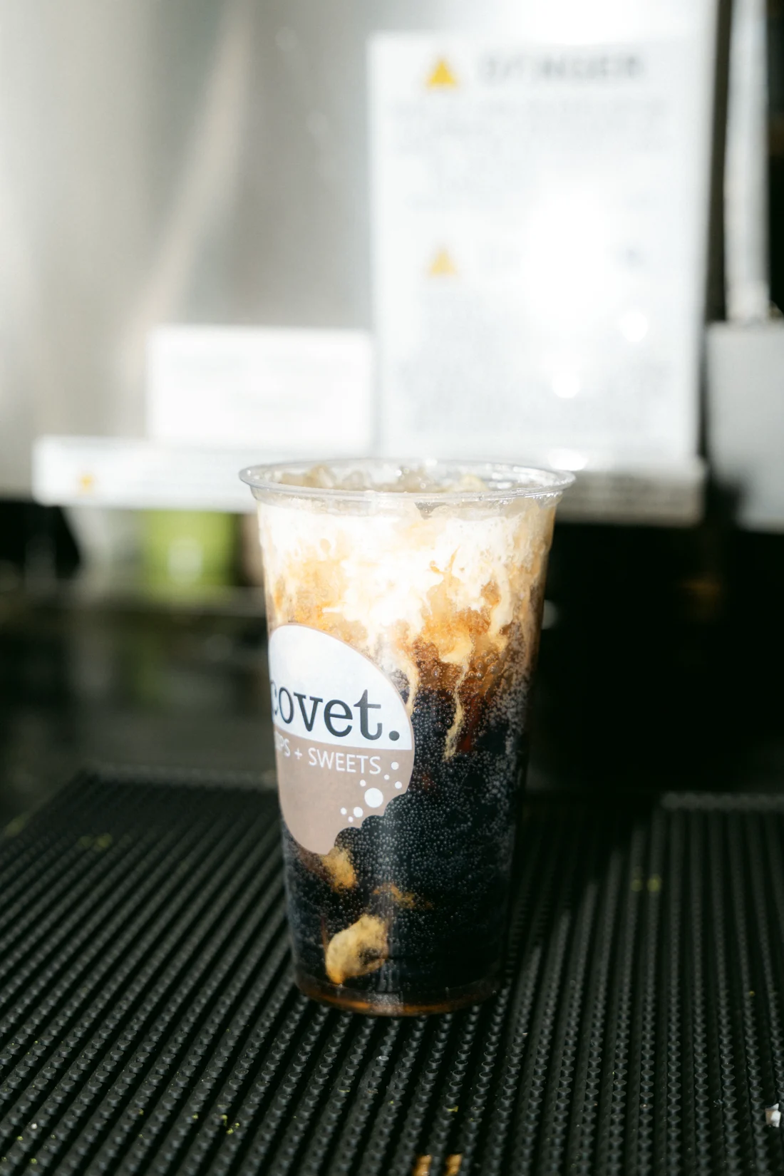 An iced milk drink streaked with brown sugar over dark pearls