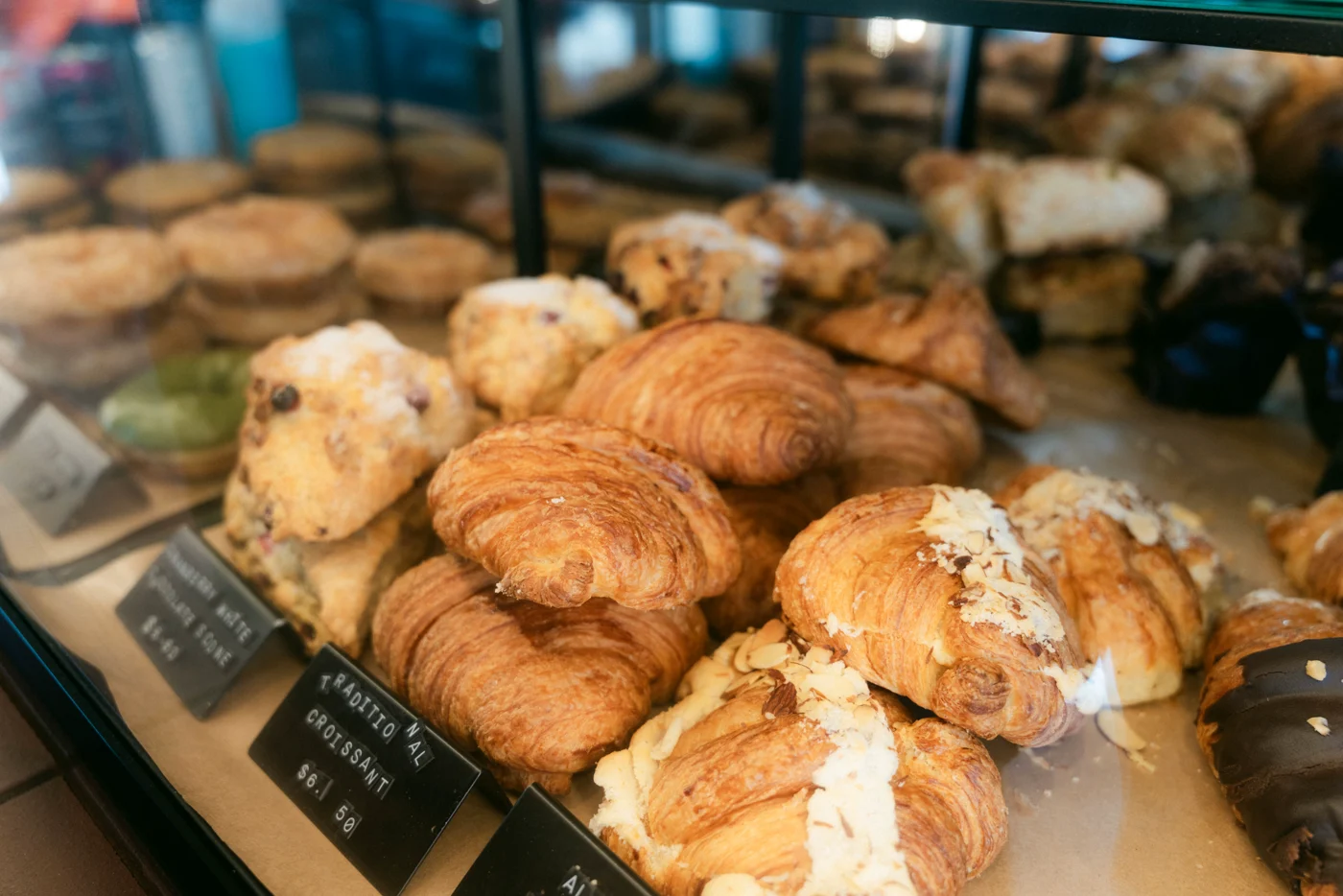 Croissants, scones and glazed pastries piled in a café display case