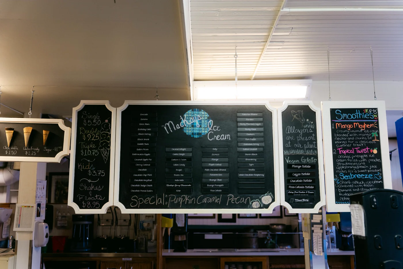 An ice cream shop's chalkboard menus under strip lights