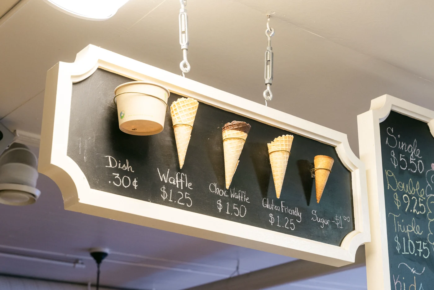 Waffle cones mounted on a chalkboard price sign