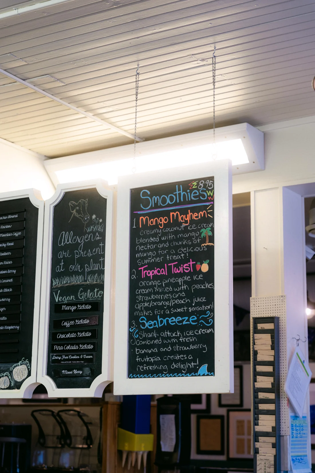 A chalkboard smoothie menu in coloured chalk under a fluorescent light