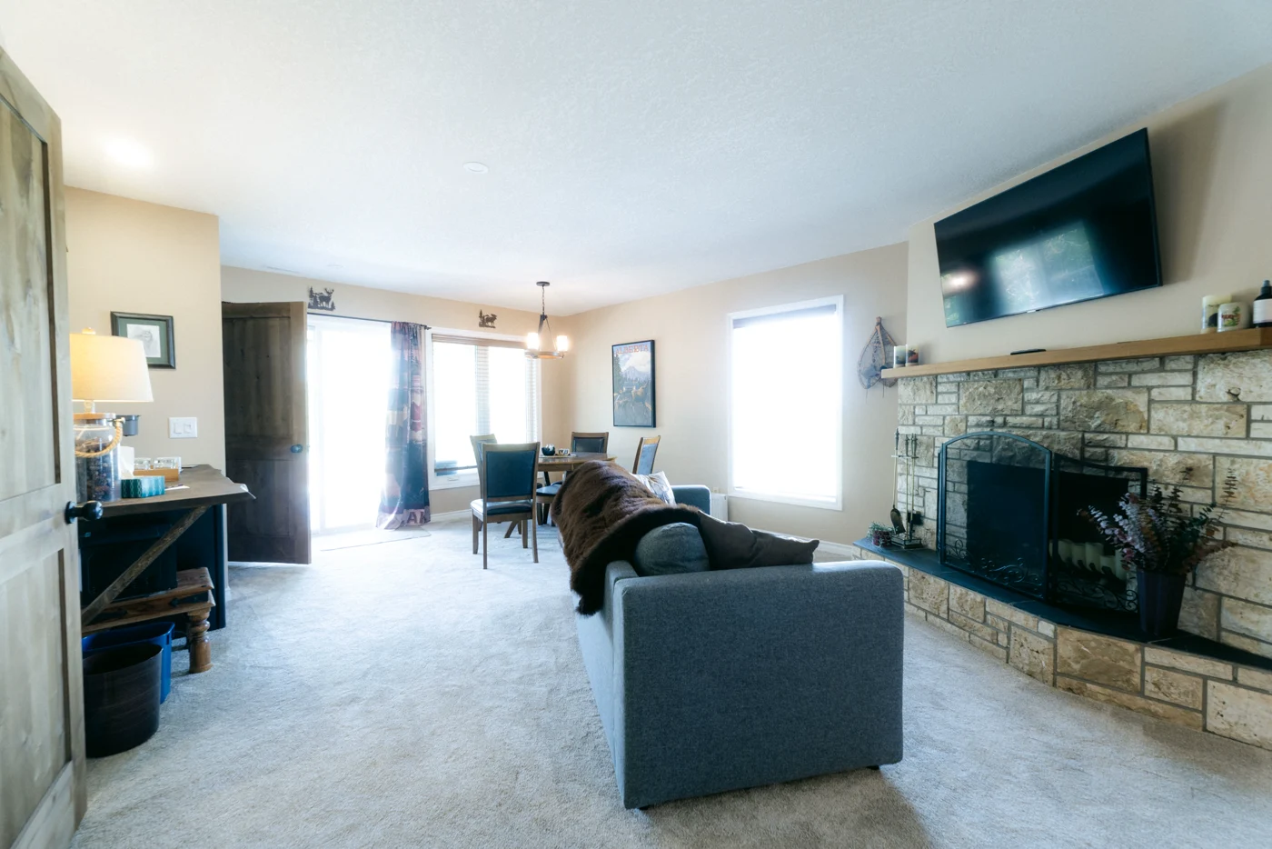 A lodge suite with a grey sofa, a stone fireplace and a television