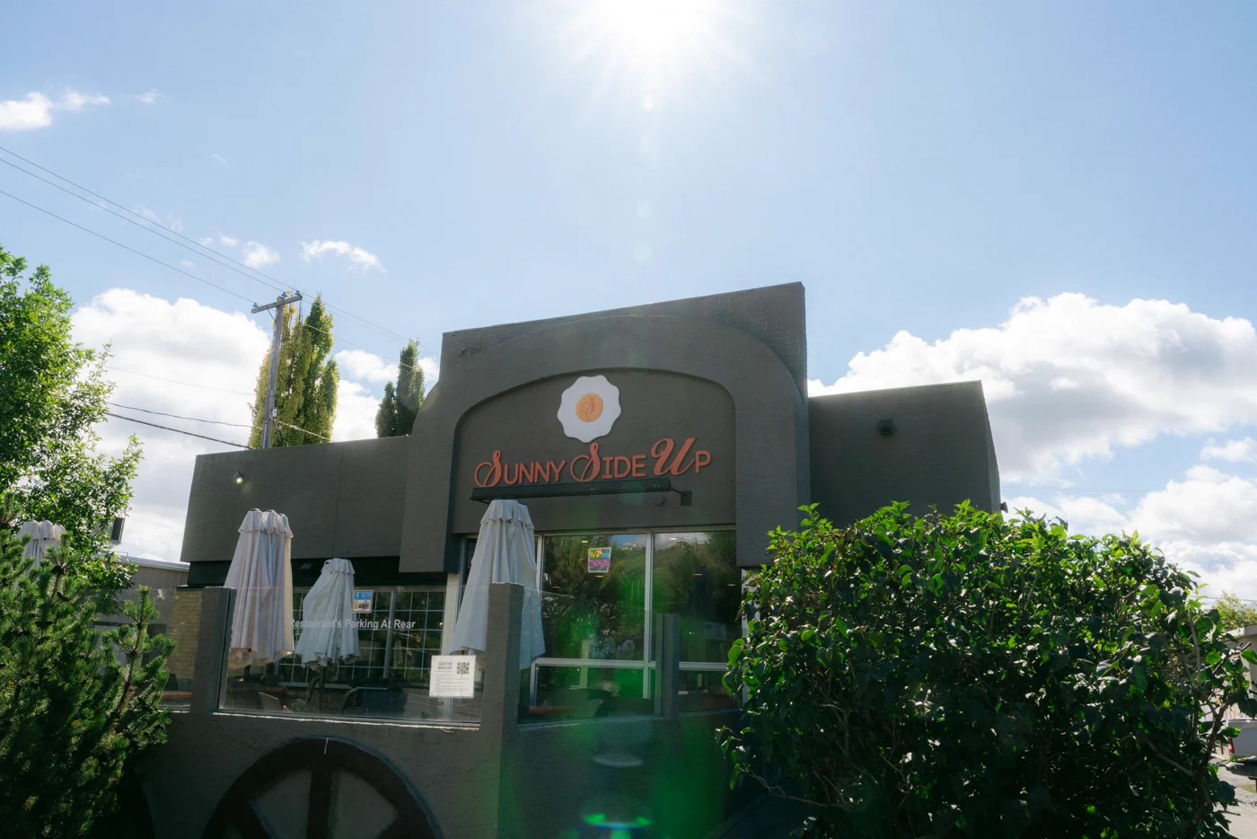 The front of a diner with patio umbrellas under a sunburst