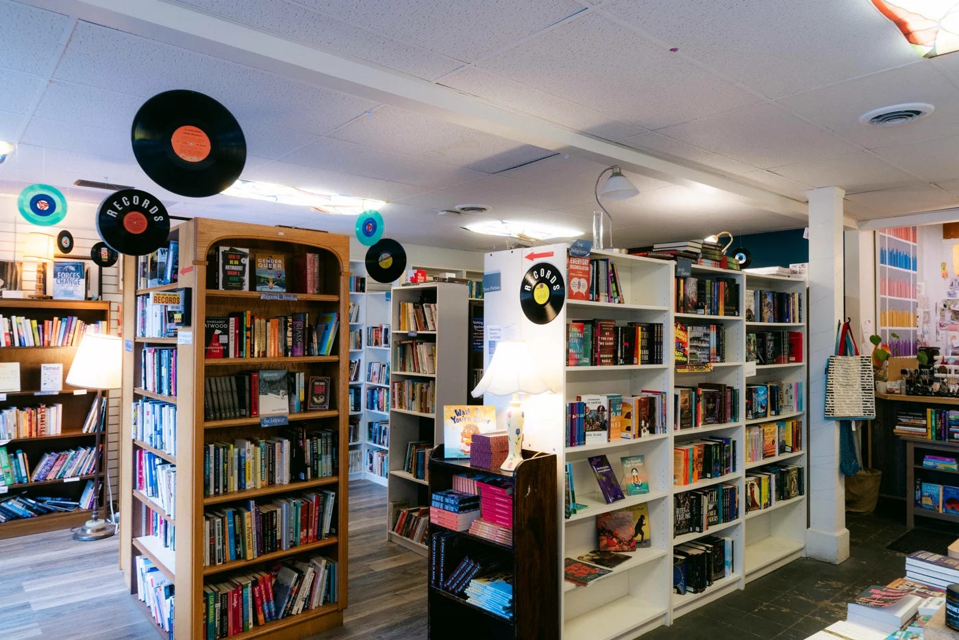 The aisles of a second-hand bookshop, records hanging from the ceiling