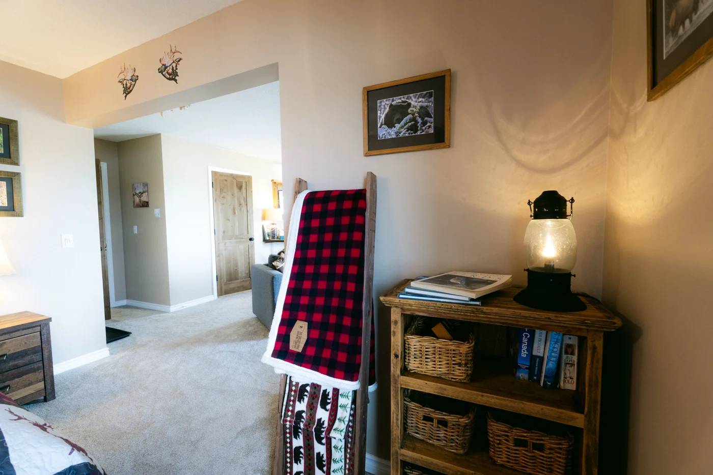A lantern and a check blanket on a rustic shelf in a lodge room