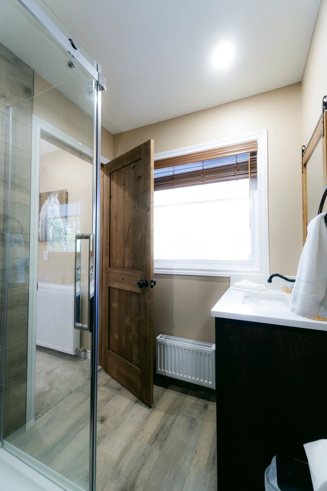 A glass shower beside a window in a lodge bathroom