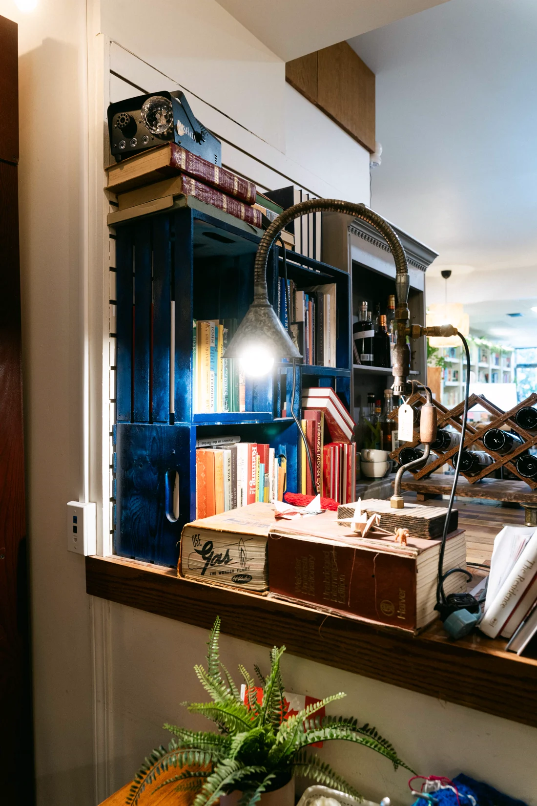 Bookshelves, a lamp and a plant in a corner of a bookshop