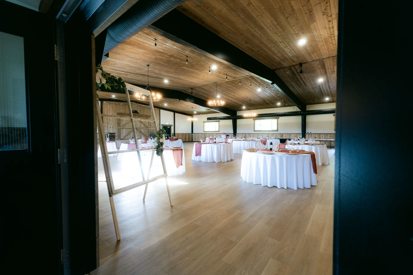 An event hall with set tables seen through a dark doorway