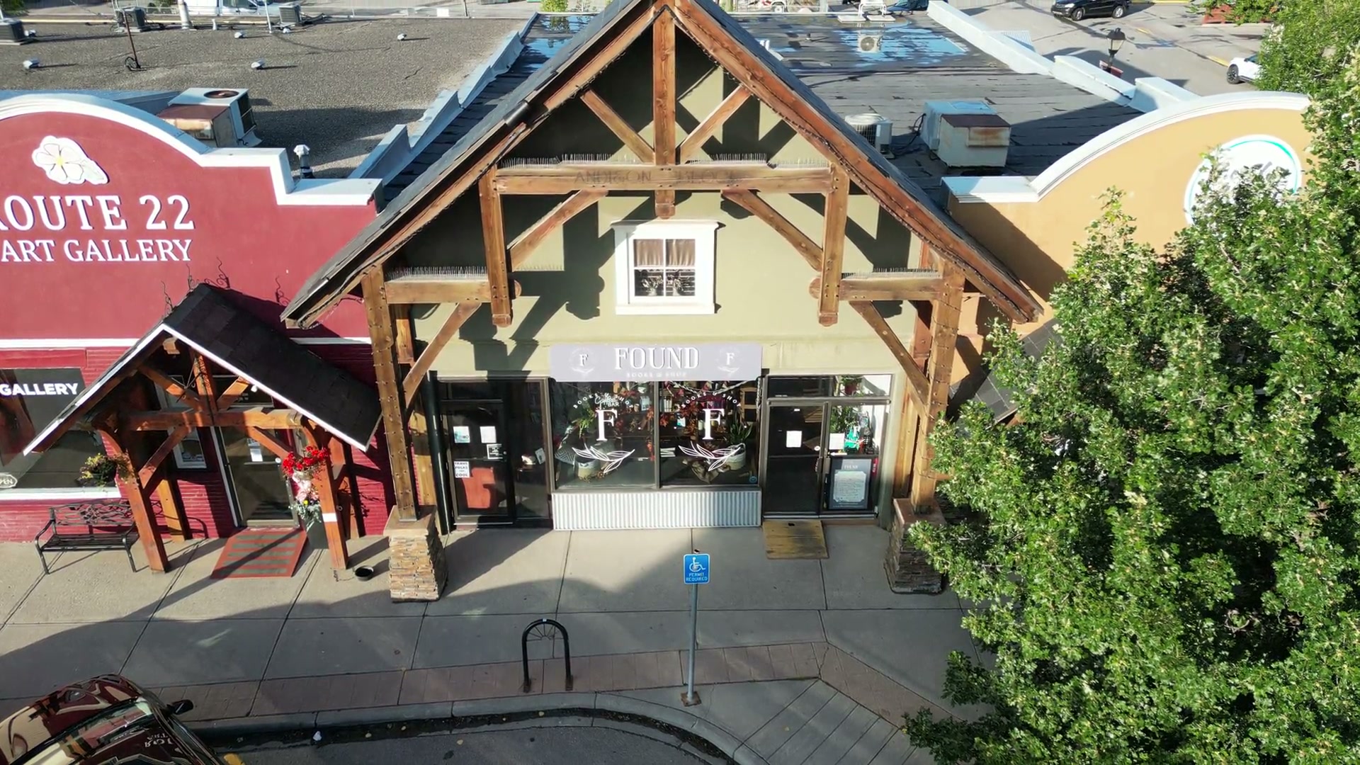 The timber-framed front of Found Books & Shop in Cochrane rising into view, Route 22 Art Gallery's red sign in the same row to the left