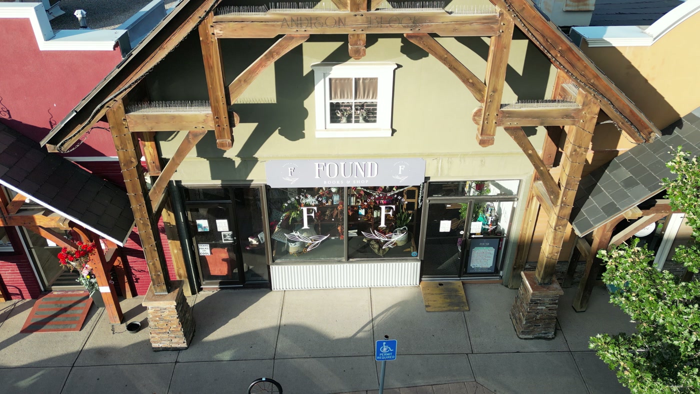 The timber frame of Found Books & Shop in Cochrane seen from just above it — posts, braces and the gable, with cream stucco above the windows