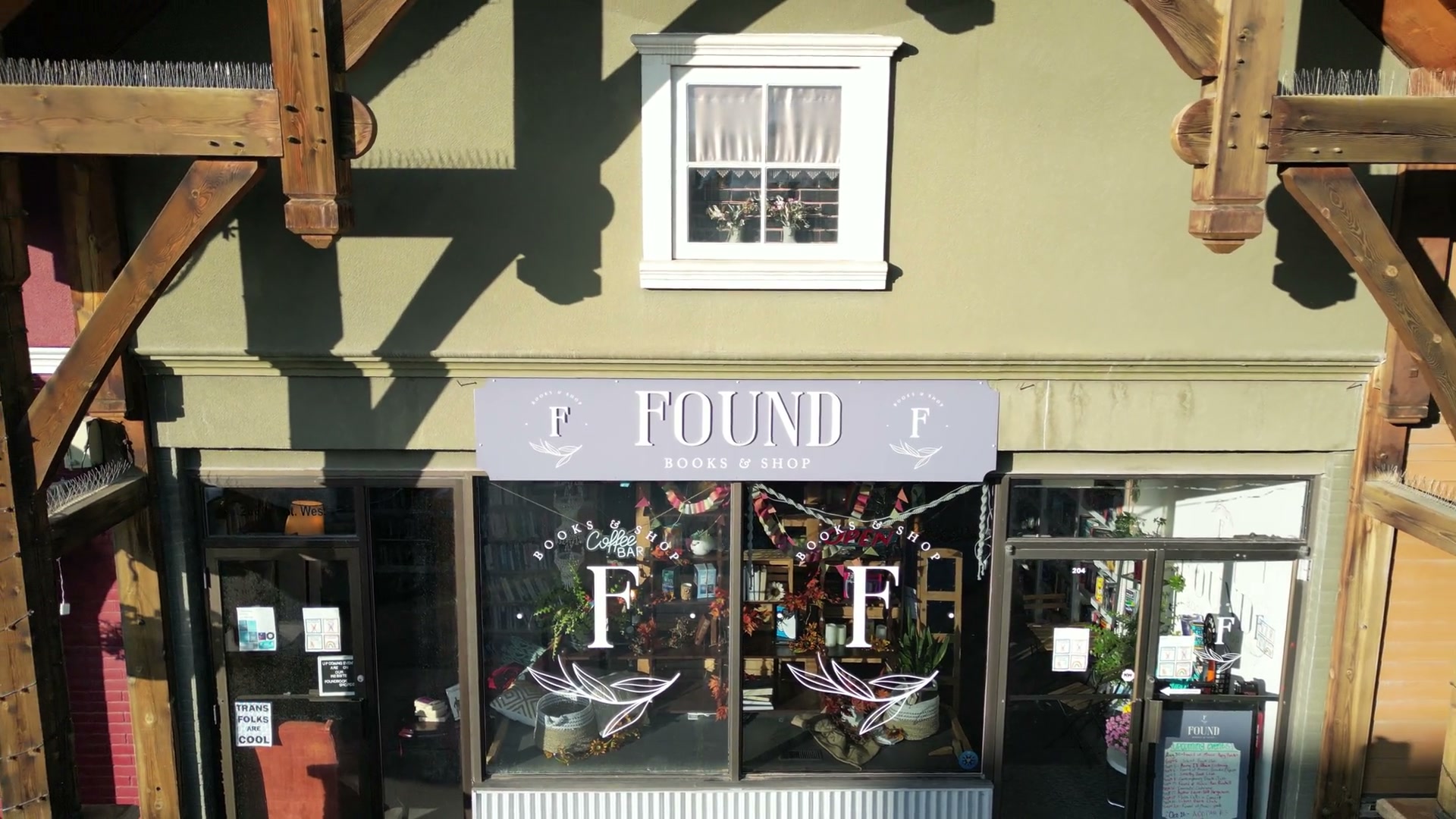 A slow pull back from the front of Found Books & Shop in Cochrane, the timber frame and the painted board receding