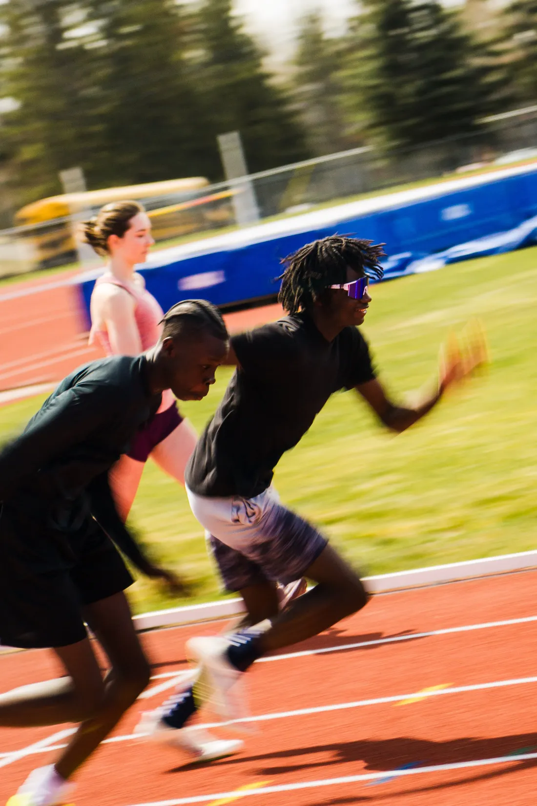 Sprinters exploding off the line on a track, the background streaked with motion blur