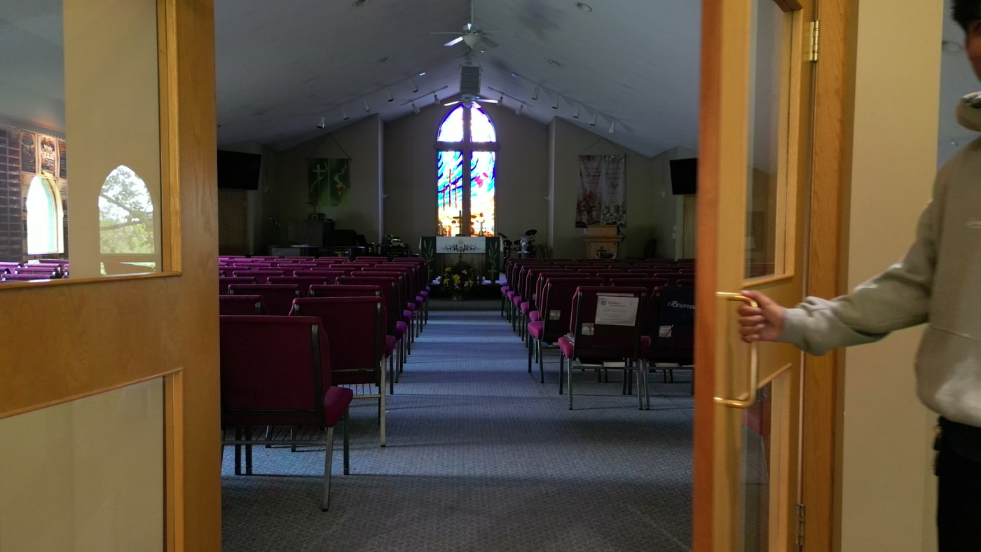 Down the centre aisle at St. Peter's in Cochrane between rows of purple chairs, the chancel and its stained-glass window ahead
