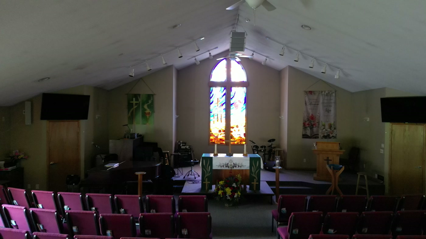 The whole sanctuary at St. Peter's Lutheran Church, Cochrane: the vaulted ceiling and its track lighting, the banners at the chancel, and the full floor of chairs