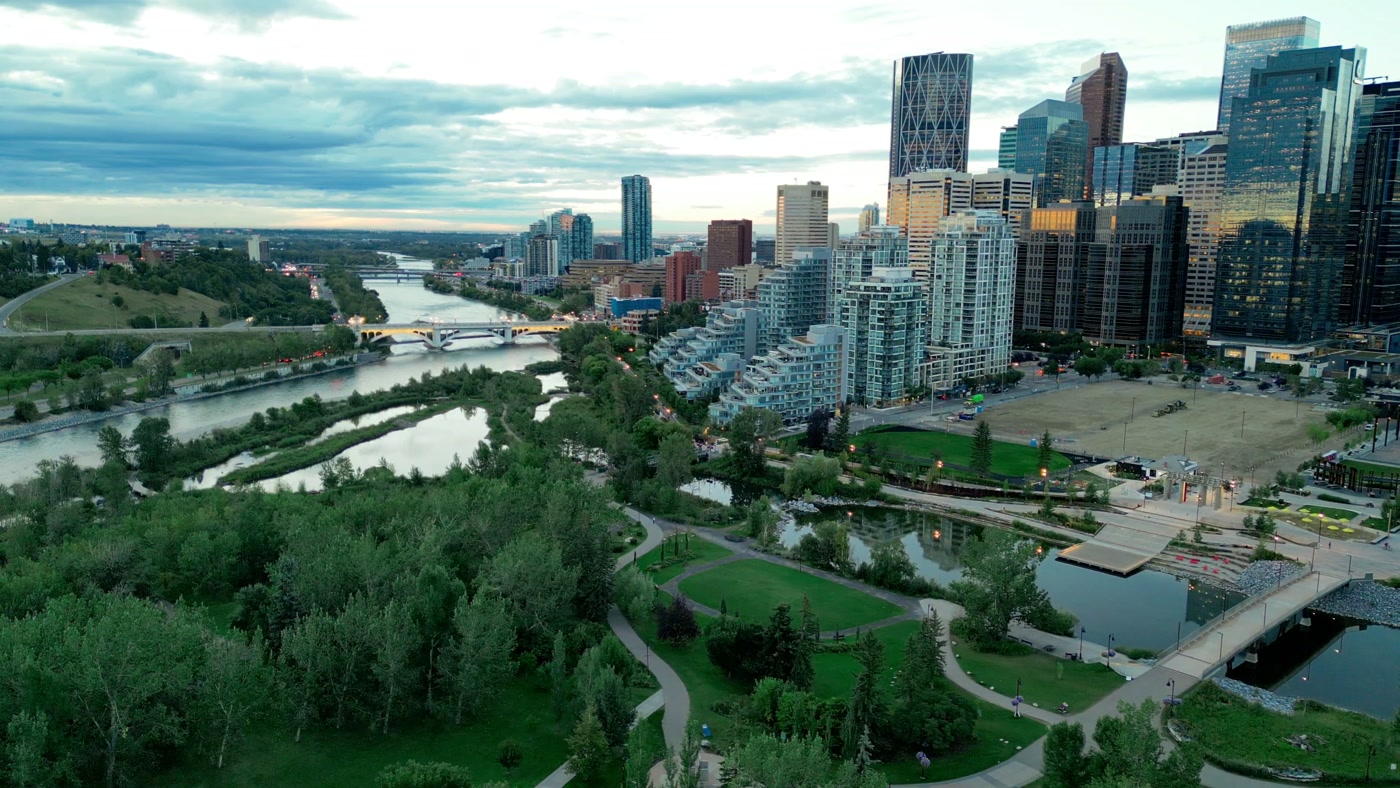 Prince's Island Park from above at dusk: the wetland at its east end, the lagoon, the Eau Claire towers and the Centre Street Bridge downstream