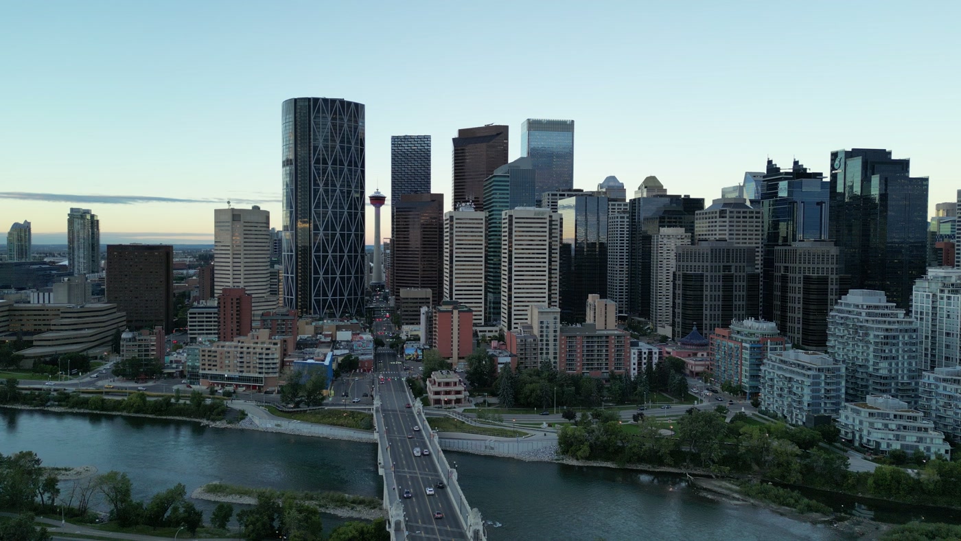 The Calgary Tower at the end of Centre Street, seen from above the Bow River, The Bow's dark crescent beside it and the office towers behind