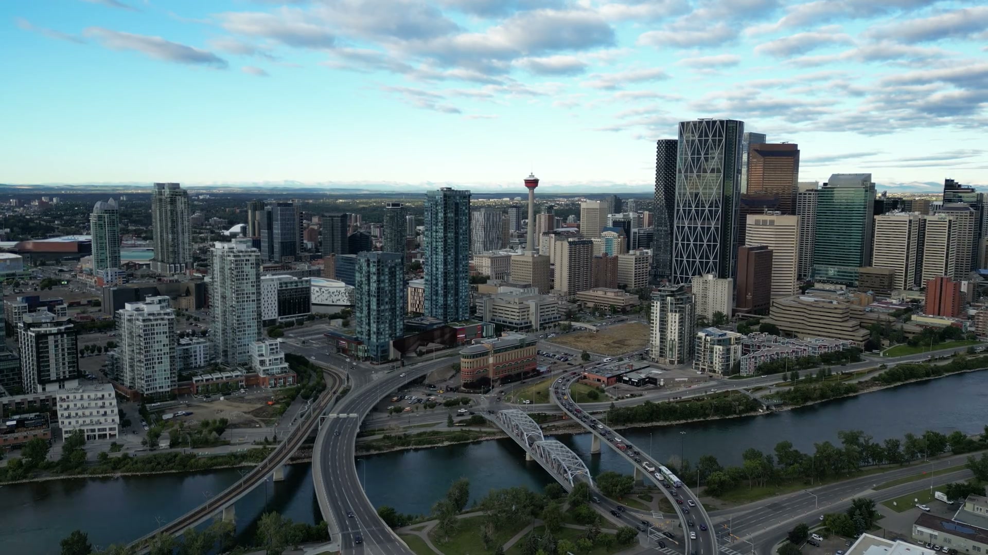 Downtown Calgary from above the Bow River: the Calgary Tower, the Bow tower and the bridges under a bright evening sky