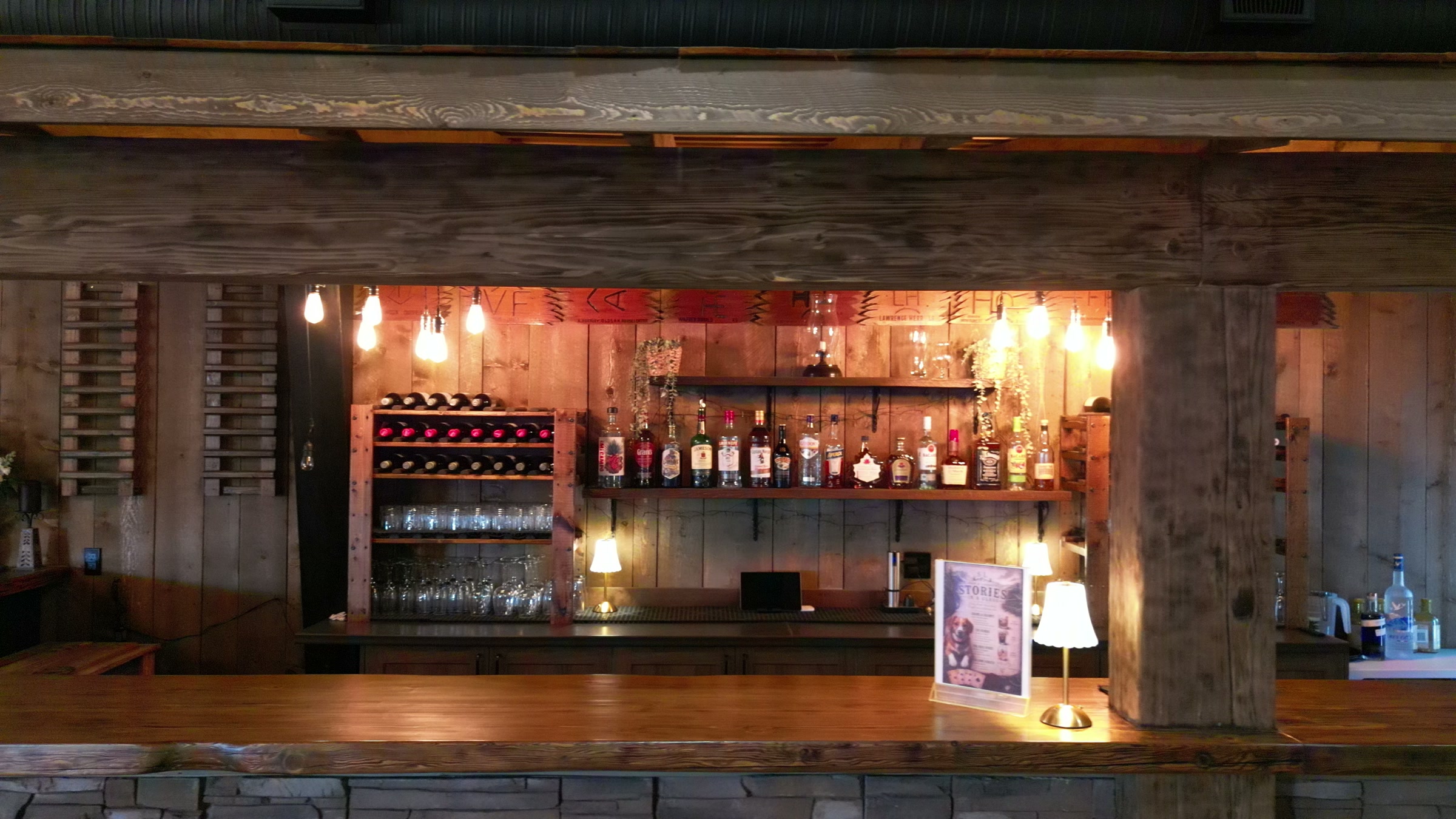 The bar of the wedding venue, lit warm under timber beams