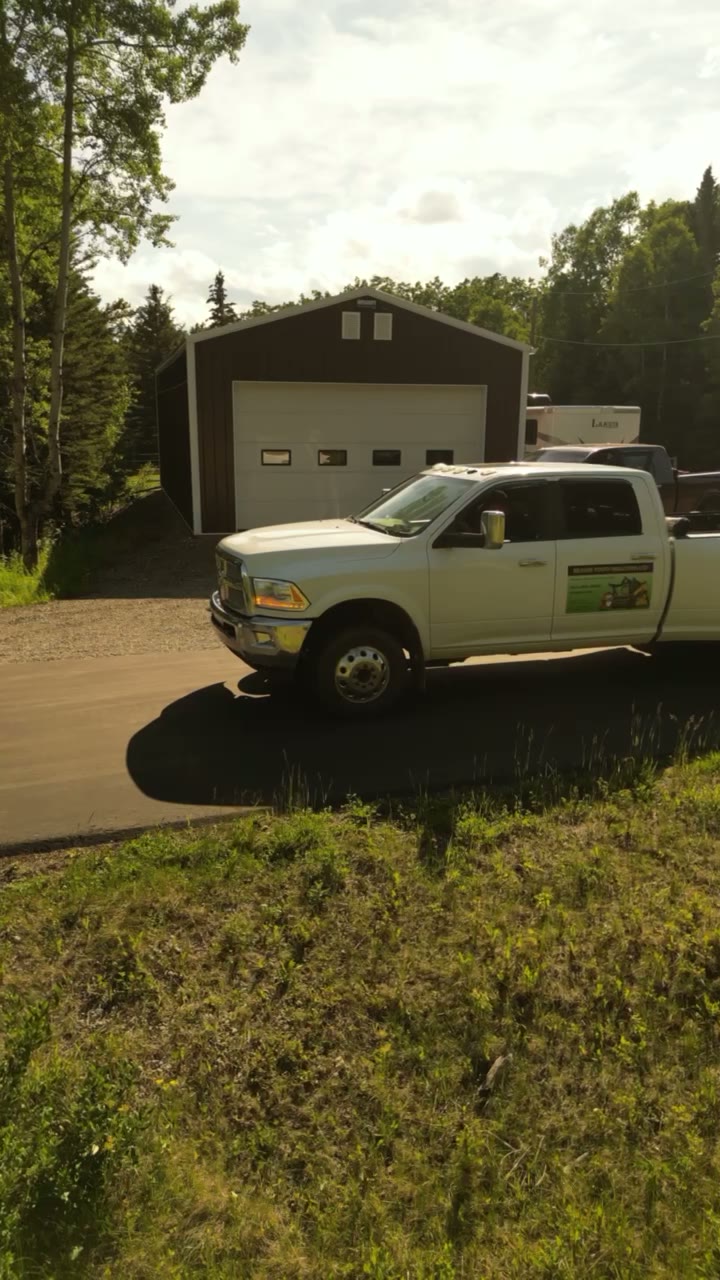 A dually pickup and trailer outside an equipment shop